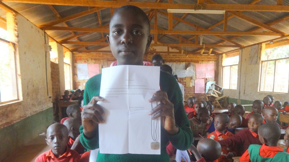 Στην φωτογραφία φαίνεται η αίθουσα του σχολείου και η Wavinya που δείχνει στην κάμερα το γράμμα που έχει ετοιμάσει. Copyright: Elkana Nyaga